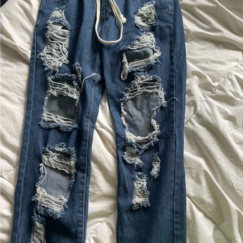 These are dark blue jeans, brand American Brazil size small with rips